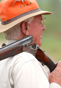 Only breeching shotguns (side-by-sides or over/unders) are used by gunners at AKC hunt tests. Whether up close in conversation, or at 100 yards, all can see when a gun is breeched and safe. This gentleman's well-used over/under shows as much character as its owner.